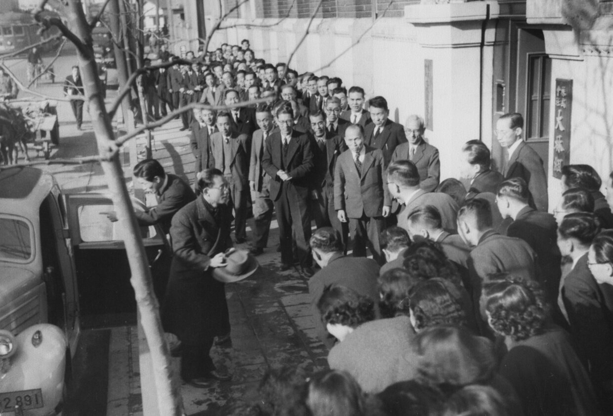アメリカから帰国した大林芳郎社長を本店玄関前で迎える役職員（1950年）