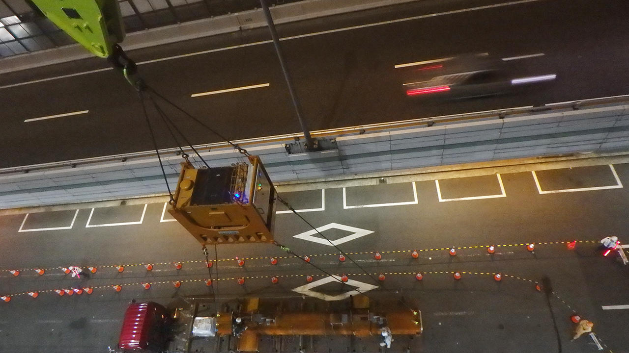 阪神高速との距離は8m。手前の一般道路を一部封鎖し、つり荷の回転を抑えるスカイジャスターで夜間に揚重