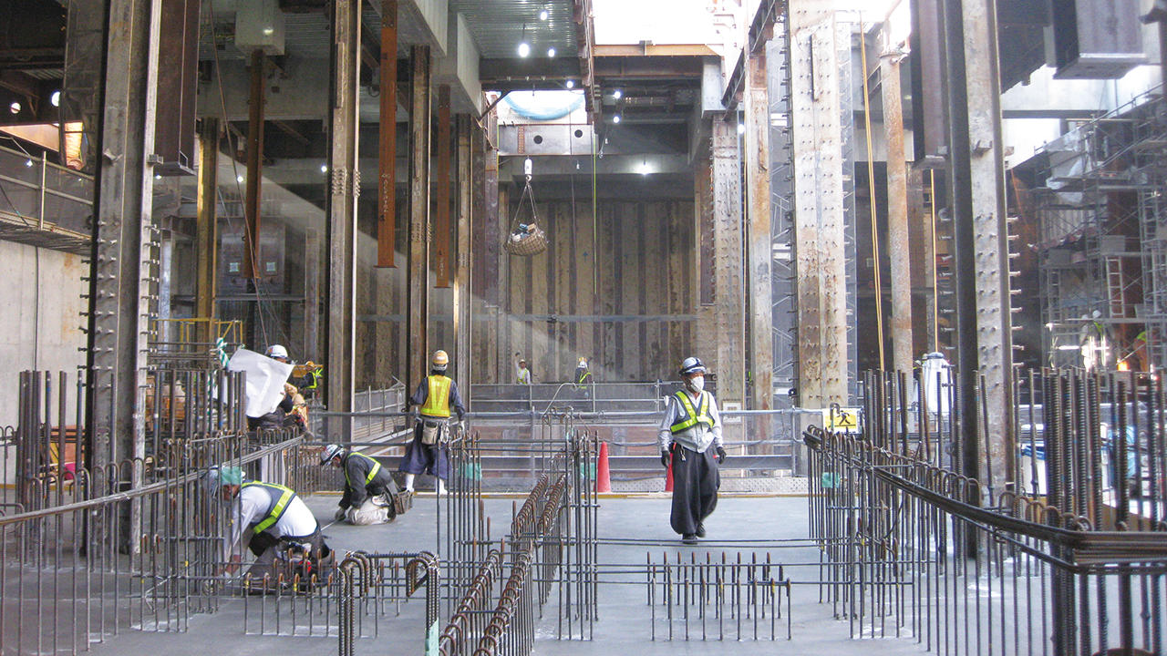 1階の床と仮設地盤アンカーでしっかりと押さえられた土留め壁(正面奥)が勝てる オンライン カジノ軌道への影響を抑止。並行して地下躯体の構築が進められた(手前)