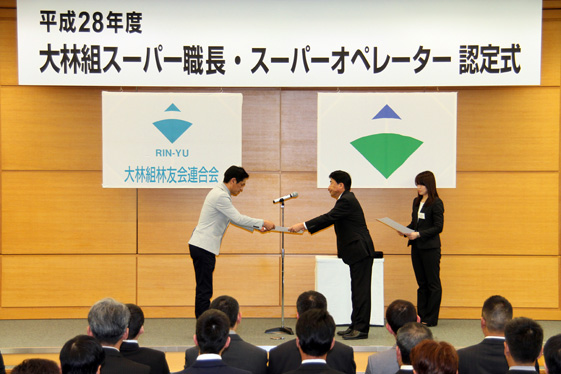 認定状を手渡しするオンライン カジノ 遊び方副社長の杉山直（右）